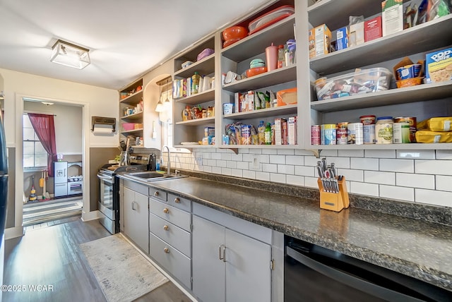 kitchen with sink, dark wood-type flooring, dishwasher, stainless steel range with electric stovetop, and tasteful backsplash