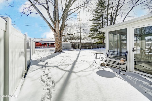 snow covered patio with a sunroom