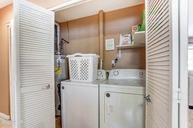 laundry room featuring water heater and washer and clothes dryer