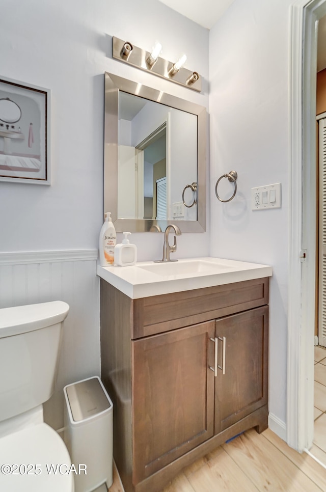 bathroom with hardwood / wood-style flooring, vanity, and toilet