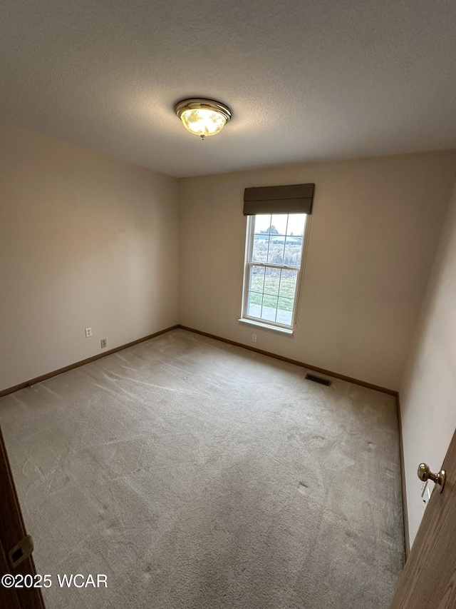 carpeted empty room with a textured ceiling