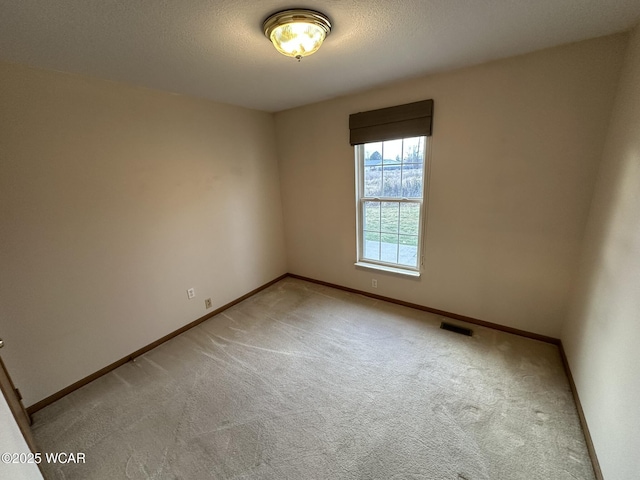 unfurnished room with light carpet and a textured ceiling