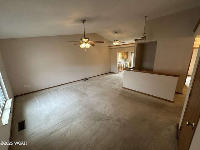 unfurnished living room with light colored carpet and vaulted ceiling