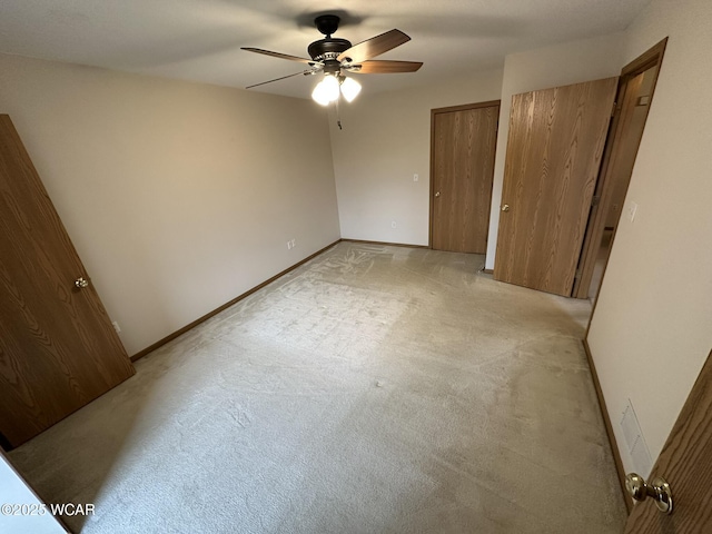 unfurnished bedroom with ceiling fan and light colored carpet