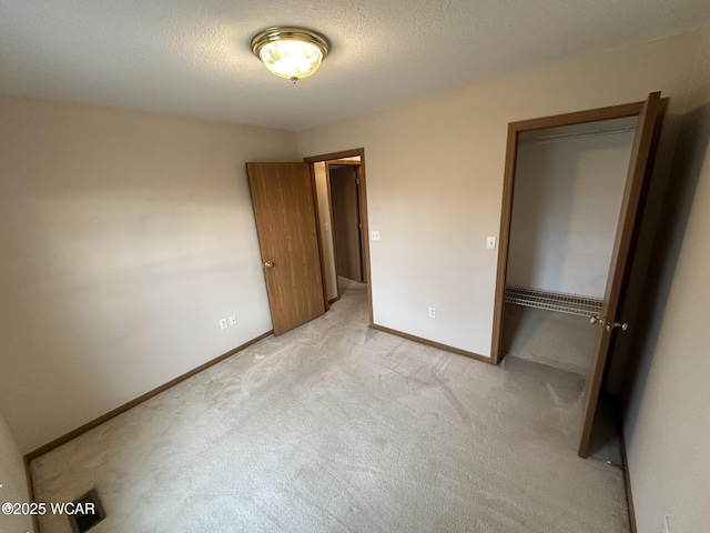 unfurnished bedroom featuring light carpet and a textured ceiling