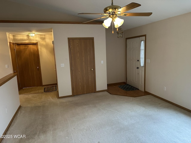 interior space with lofted ceiling, light colored carpet, and ceiling fan