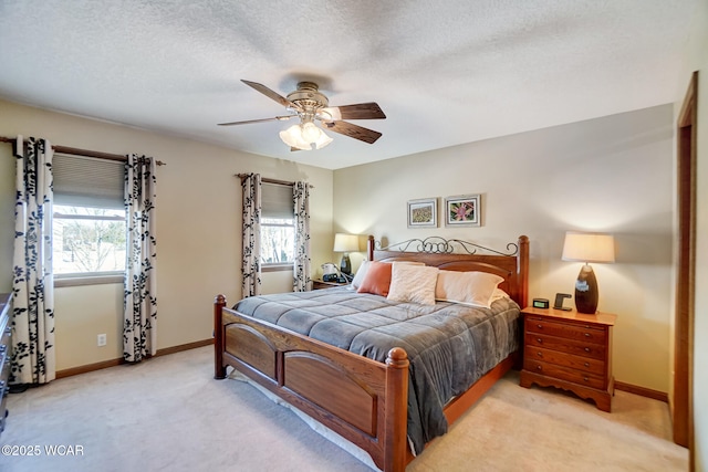 carpeted bedroom featuring ceiling fan and a textured ceiling