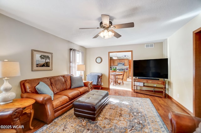 living room featuring ceiling fan and light wood-type flooring