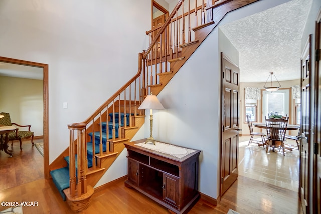 stairway with hardwood / wood-style flooring and a textured ceiling