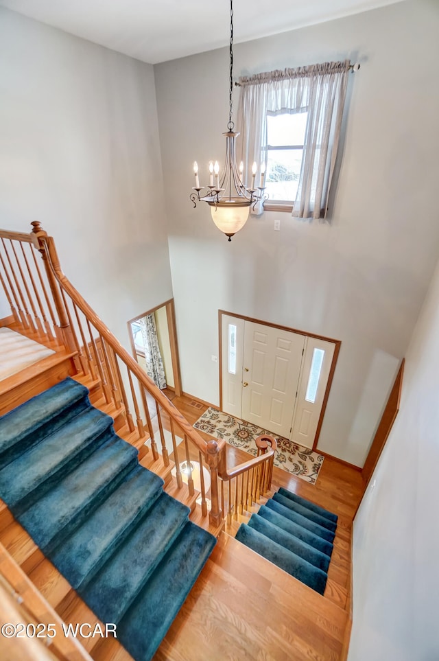 foyer entrance with an inviting chandelier and hardwood / wood-style floors