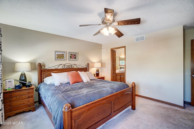 bedroom featuring ceiling fan, ensuite bath, and light carpet