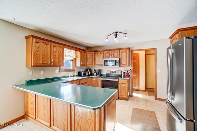 kitchen featuring stainless steel appliances, light tile patterned flooring, and kitchen peninsula