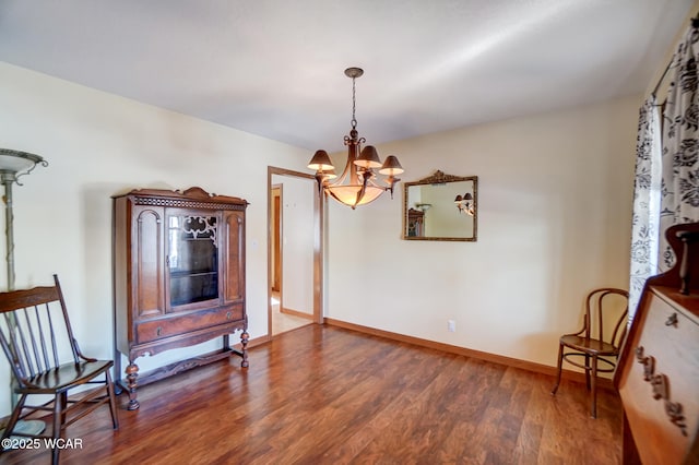 sitting room with hardwood / wood-style floors and an inviting chandelier