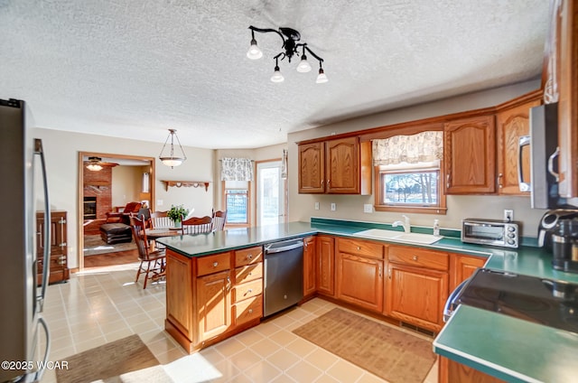 kitchen featuring appliances with stainless steel finishes, sink, hanging light fixtures, and light tile patterned floors