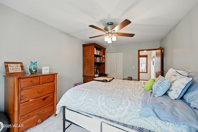 bedroom featuring a closet, light carpet, and a ceiling fan