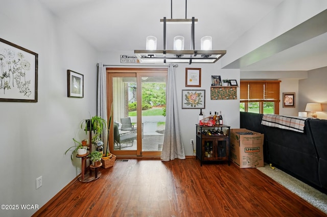 doorway to outside featuring a wealth of natural light, baseboards, and wood finished floors