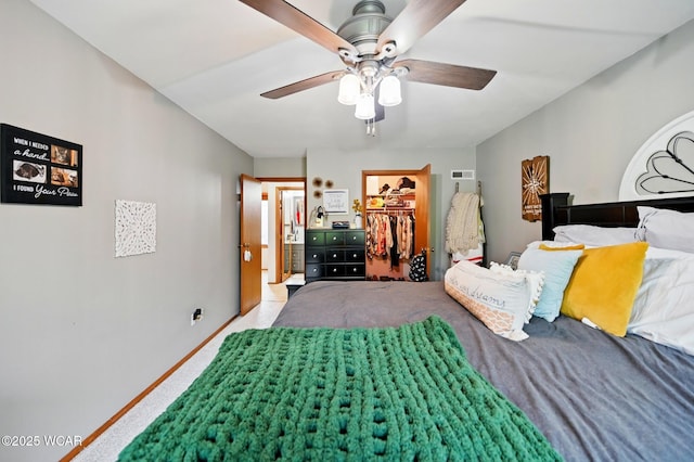 bedroom featuring a closet, carpet flooring, ceiling fan, visible vents, and a spacious closet