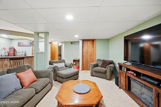 living room with wet bar, a drop ceiling, and carpet floors