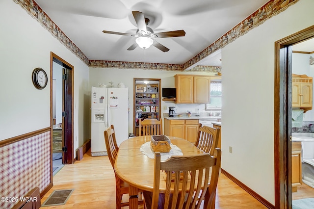 dining space featuring visible vents, baseboards, a ceiling fan, and light wood finished floors