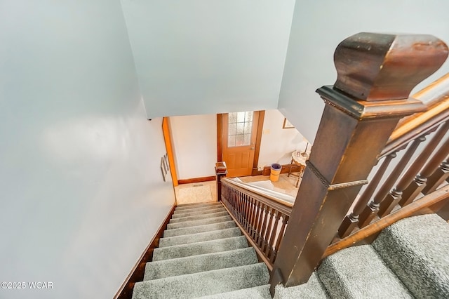 stairway featuring carpet flooring and baseboards