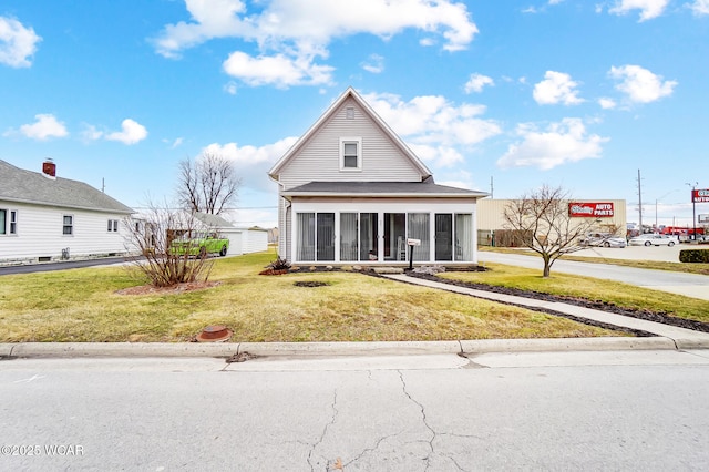 view of front facade with a front yard and a sunroom