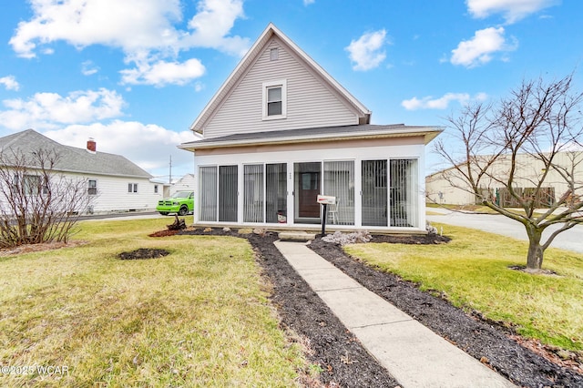 back of property with a lawn and a sunroom