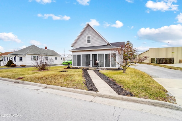 view of front facade featuring a front yard and a sunroom