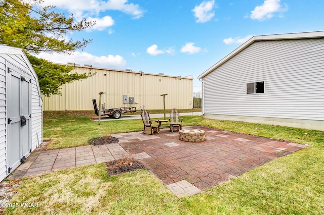 view of patio / terrace featuring an outbuilding, a shed, and a fire pit