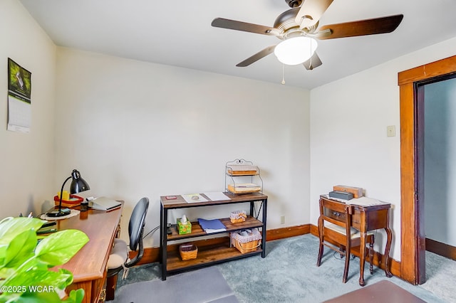 carpeted office space with ceiling fan and baseboards