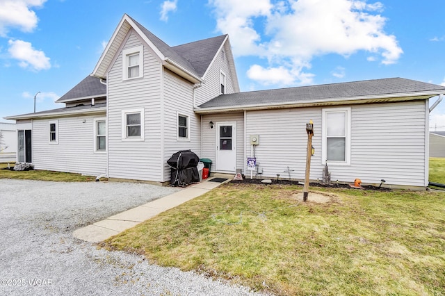 rear view of property featuring a lawn