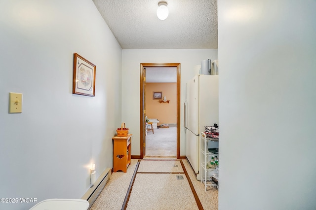 hallway with light colored carpet, baseboard heating, and a textured ceiling