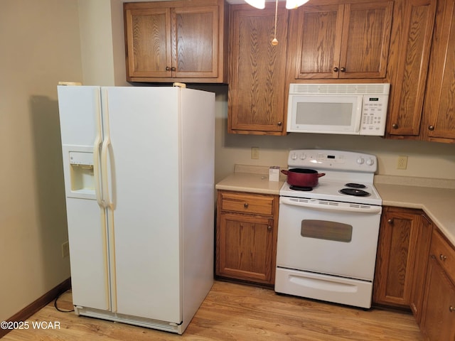 440 Edwards St, Ada, OH 45810 - kitchen featuring white appliances, brown cabinets, light countertops, and light wood-style flooring