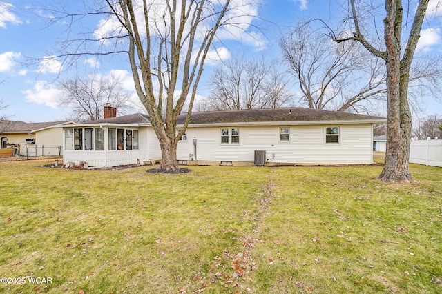 back of property featuring a sunroom, a yard, and central AC unit