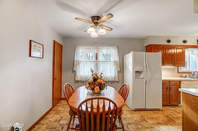 dining room with ceiling fan and sink