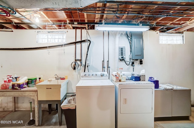 clothes washing area with sink, electric panel, and independent washer and dryer