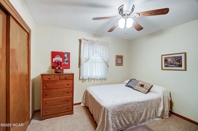 carpeted bedroom with ceiling fan and a closet