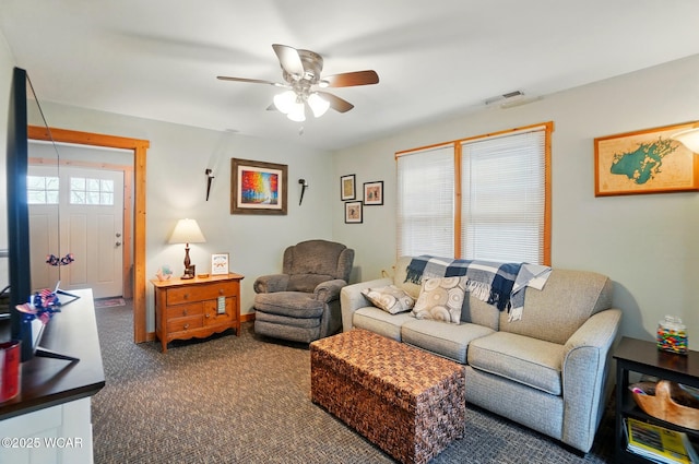 living area featuring carpet floors, ceiling fan, and visible vents