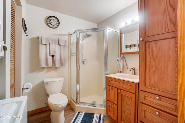 full bath featuring toilet, a shower stall, wood finished floors, and vanity