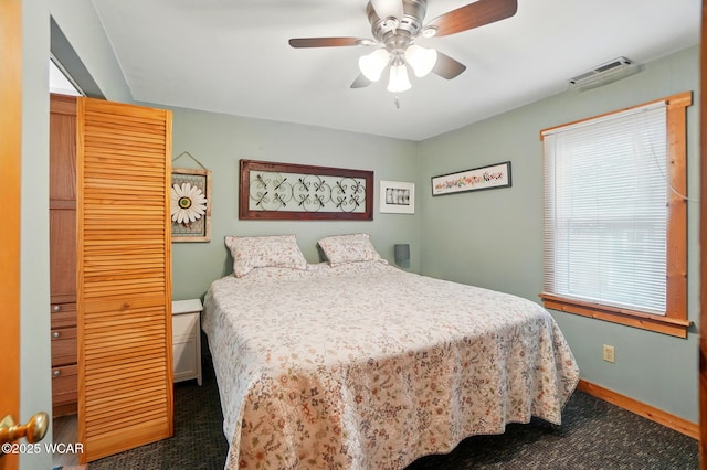 bedroom with a ceiling fan, baseboards, visible vents, and dark carpet