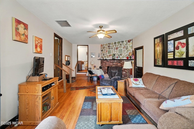 18698 Rd 48, Grover Hill, OH 45849 - living room with light wood-type flooring, a brick fireplace, ceiling fan, and stairs