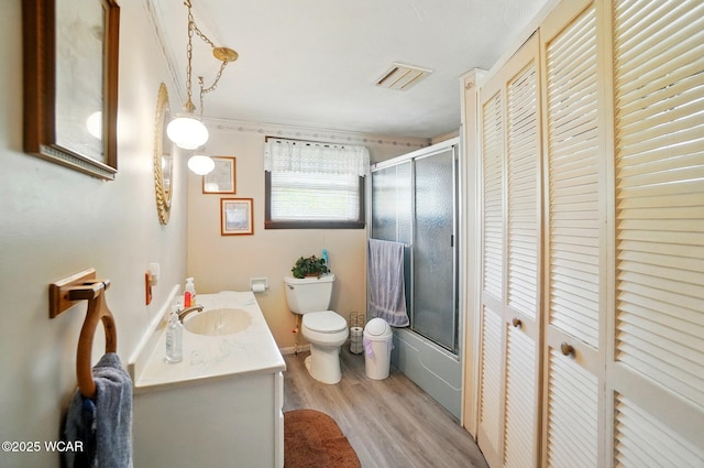 18698 Rd 48, Grover Hill, OH 45849 - bathroom with toilet, vanity, wood finished floors, a closet, and combined bath / shower with glass door
