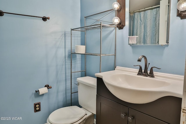 bathroom with vanity, a shower with shower curtain, and toilet