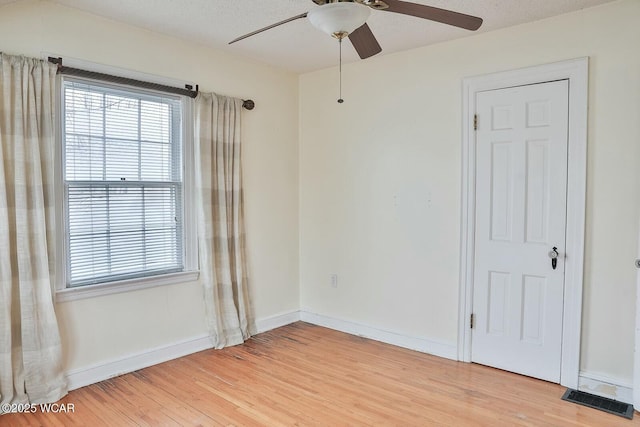 spare room with a textured ceiling, ceiling fan, and light hardwood / wood-style flooring