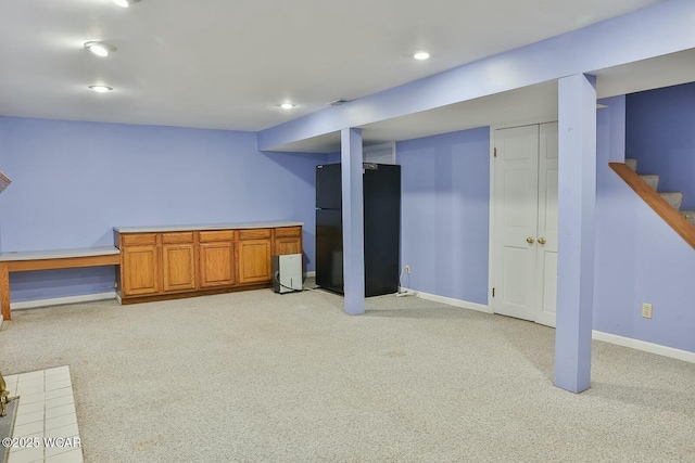 basement featuring black fridge and light colored carpet