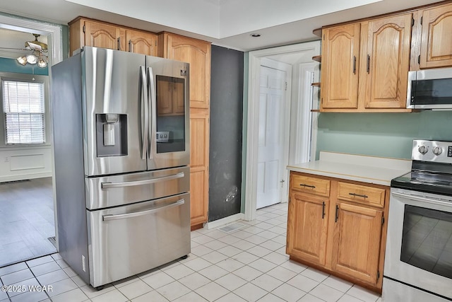 kitchen with light tile patterned floors, ceiling fan, and appliances with stainless steel finishes