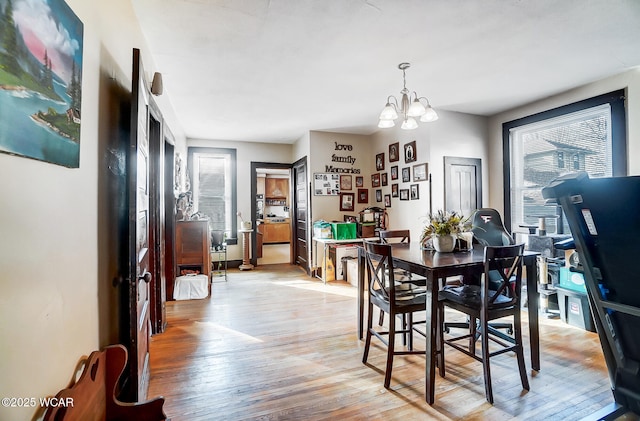 dining area with a notable chandelier and light hardwood / wood-style flooring