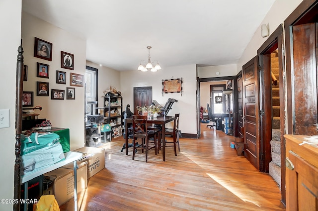 dining space with a notable chandelier and light hardwood / wood-style flooring