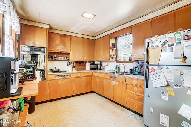 kitchen featuring gas cooktop, stainless steel fridge, and sink