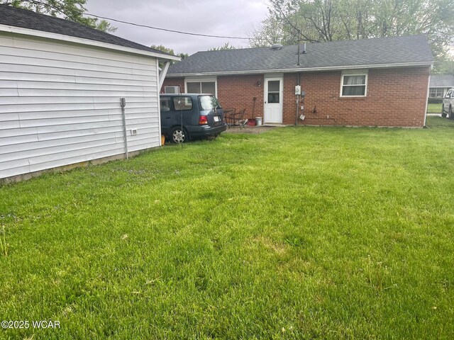 1121 Bahama Dr, Lima, OH 45801 - back of property with a yard, brick siding, and a shingled roof
