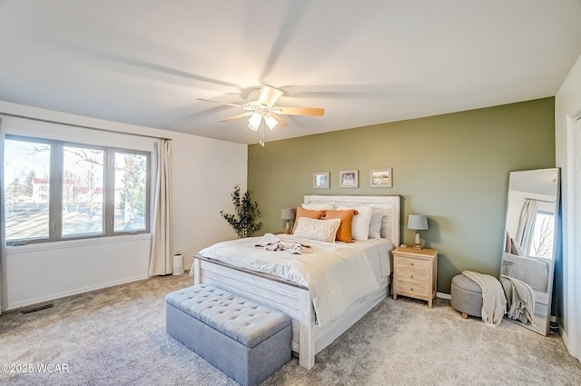 bedroom featuring visible vents, light carpet, baseboards, and ceiling fan